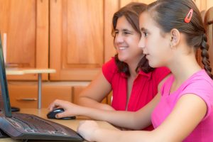 mother with girl at computer