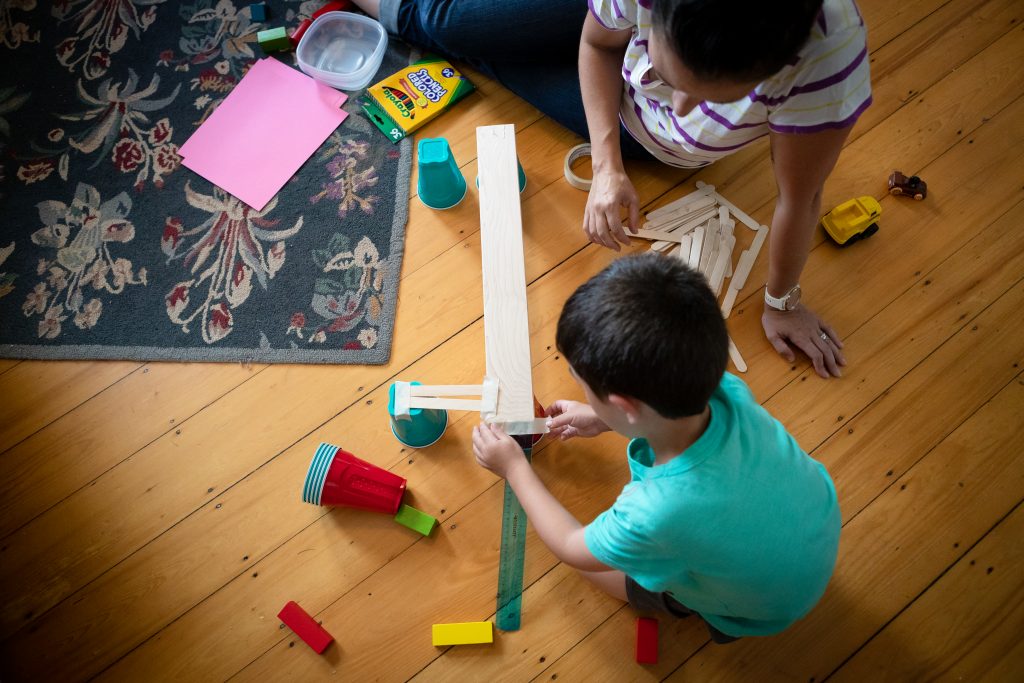 Mother and child play with household objects