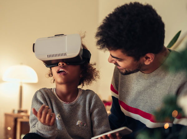child and father using VR at home; shutterstock