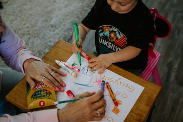 boy and caregiver with markers