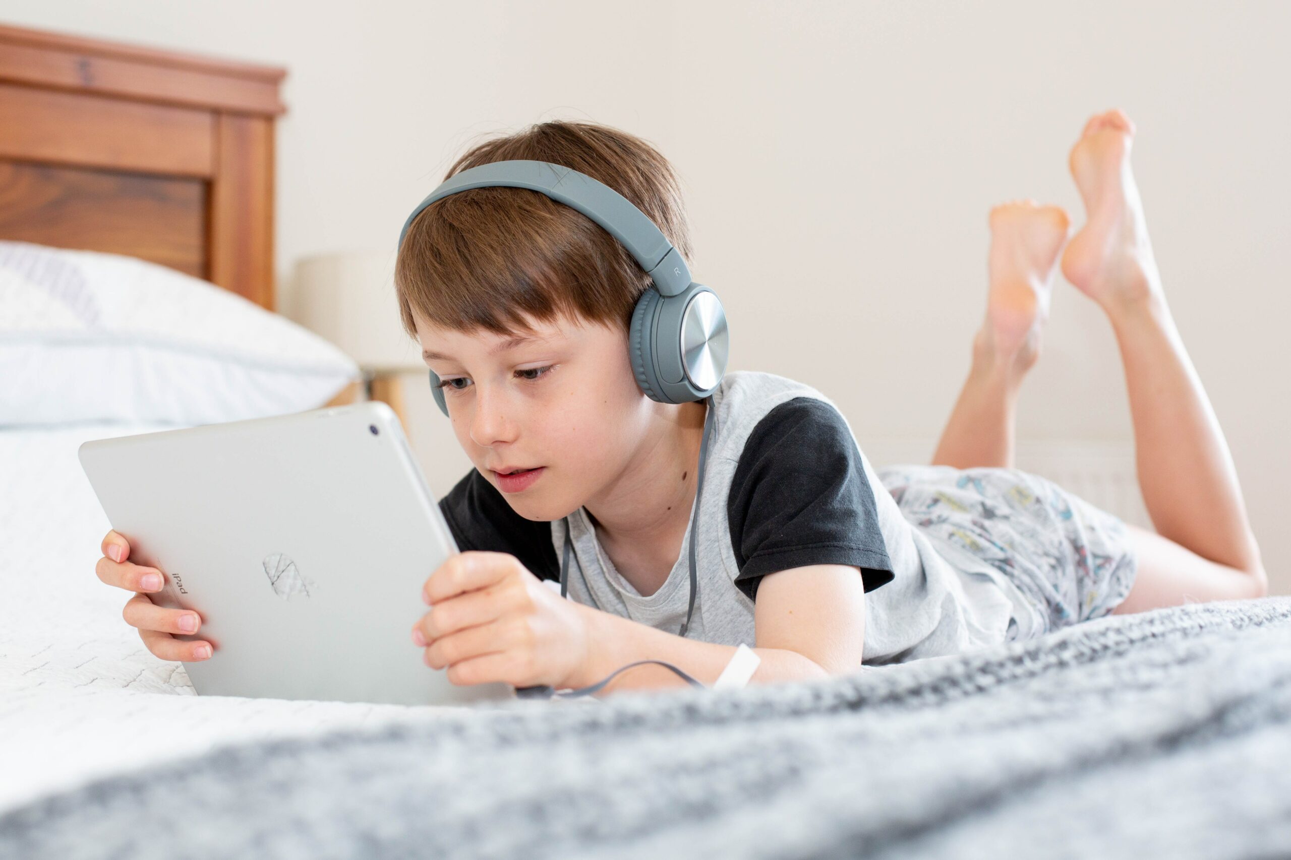 boy with headphones playing on tablet