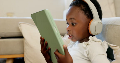 young child reading on a tablet