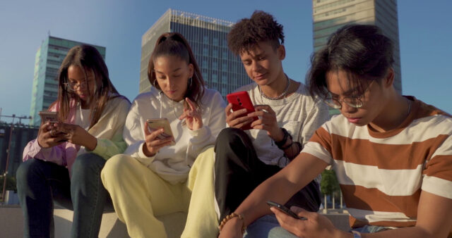 group of teenagers looking at their phones